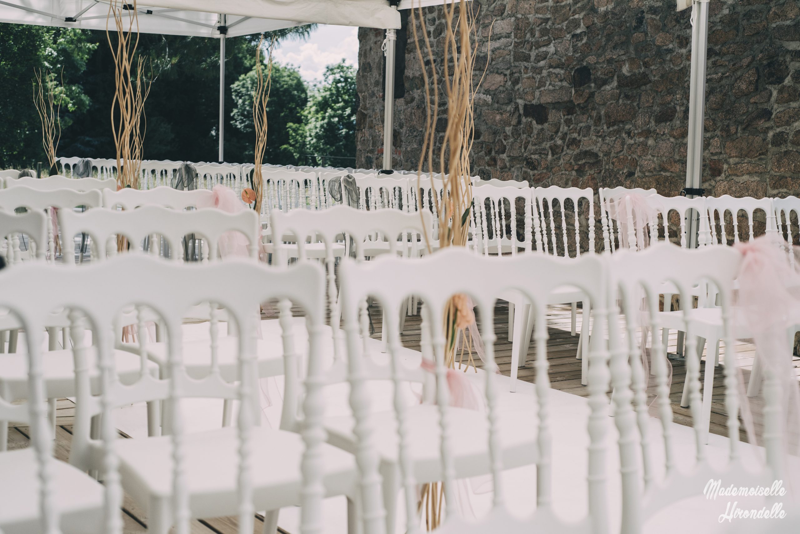 Chaises de cérémonie blanches installées en extérieur