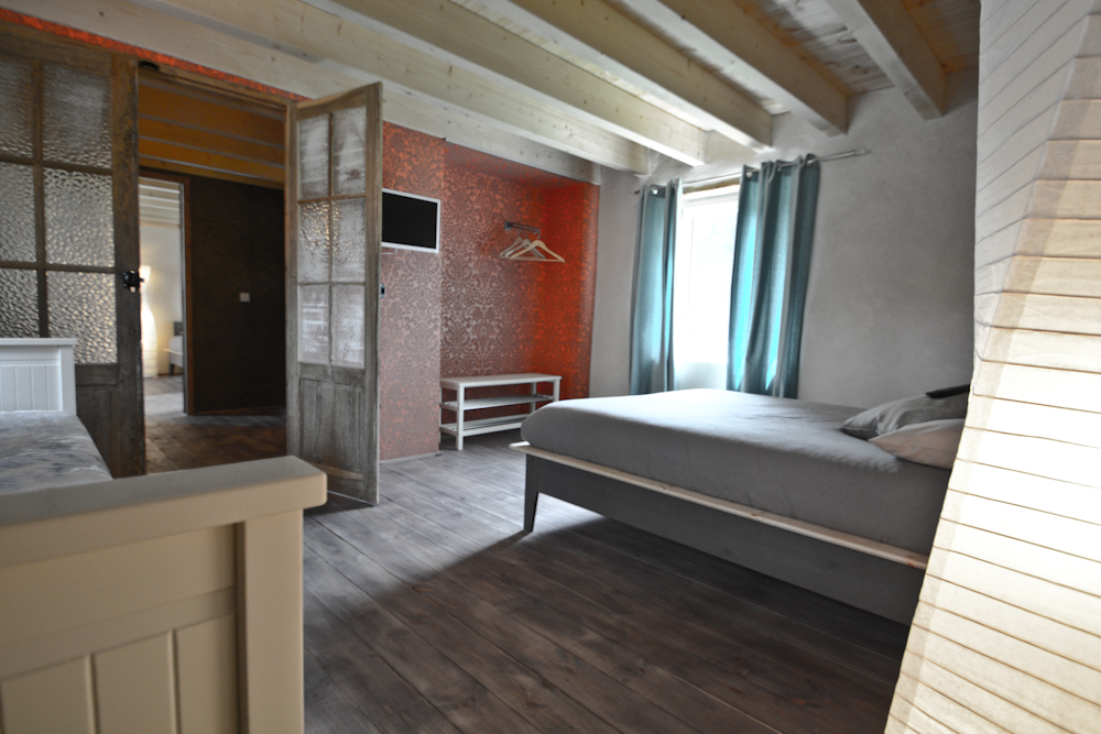 Chambre aux murs colorés et poutres apparentes