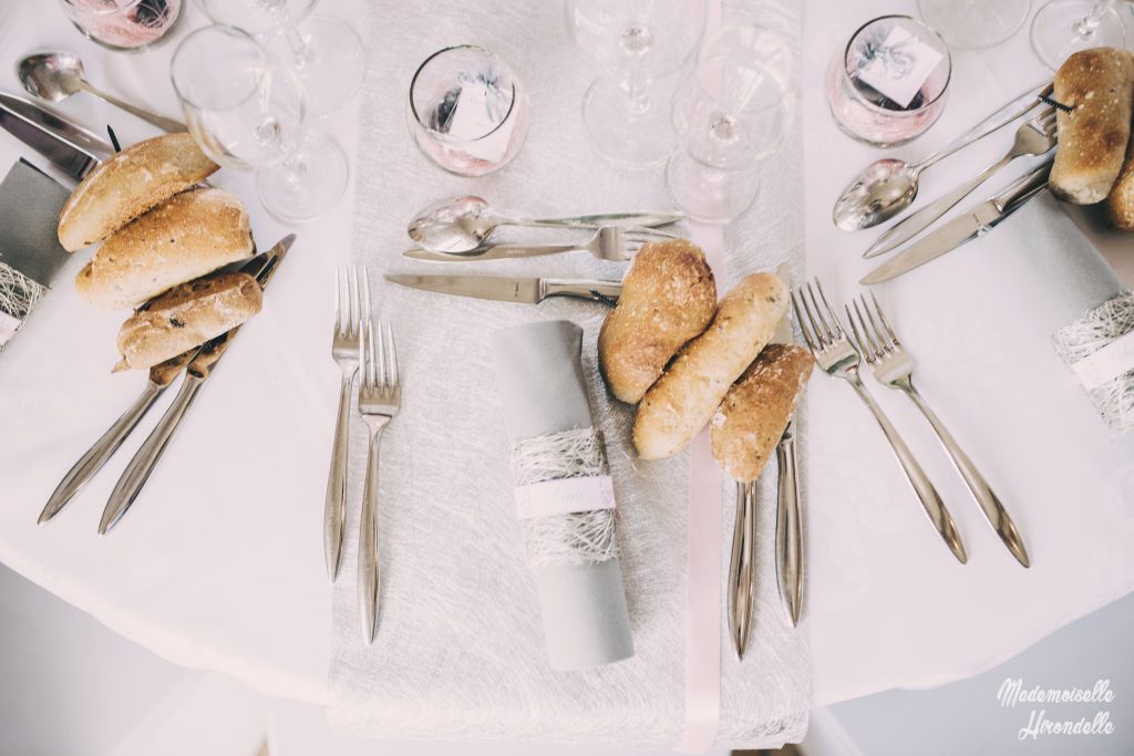 Couverts et pains dressés sur une table de mariage